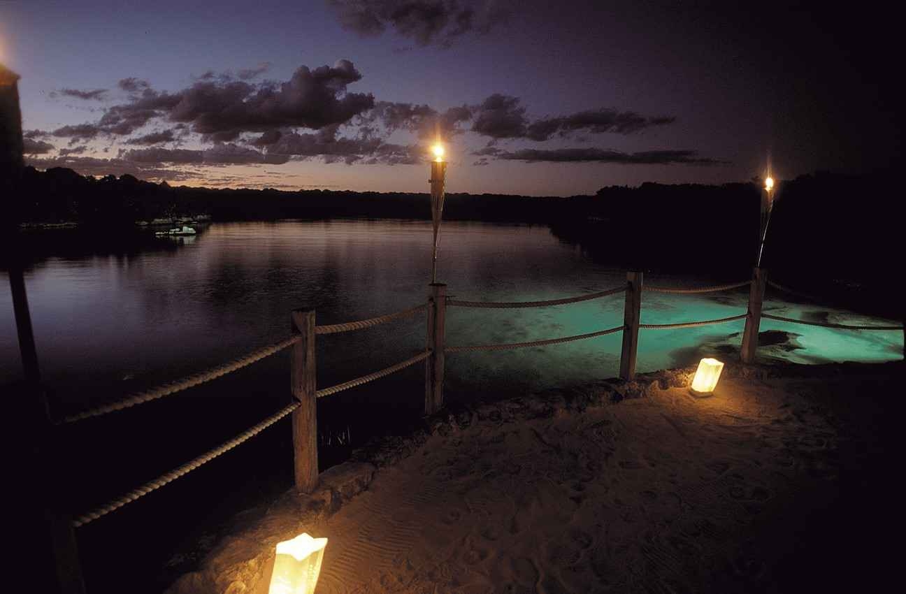 A candlelit walkway near the Cozumel coastline.