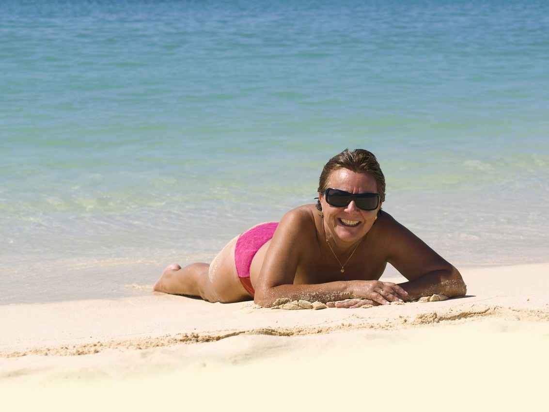 A topless woman lying facedown on a beach in Playa Del Carmen.