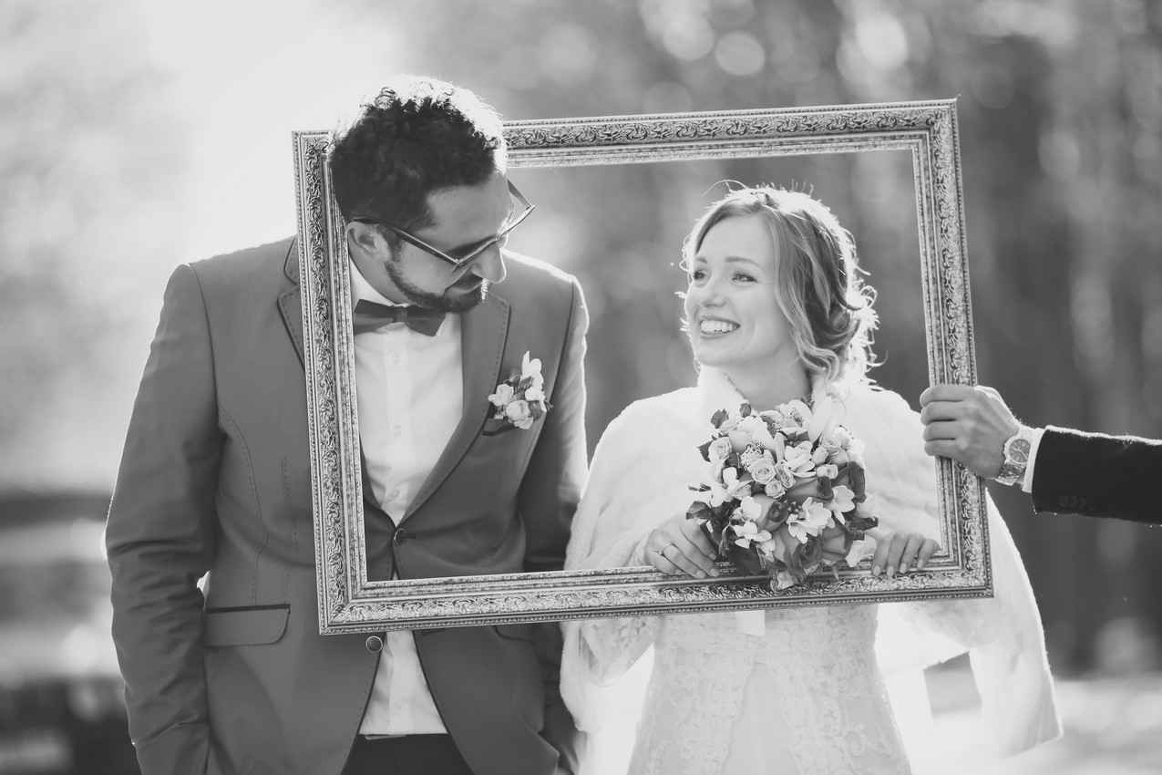 A black-and-white photograph of a bride and groom in a picture frame.