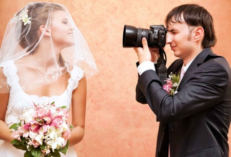 A groom taking a picture of a bride before their wedding ceremony.