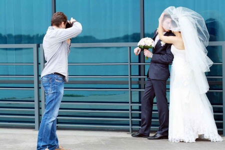 A photographer taking pictures of a bride and groom in Cancun.