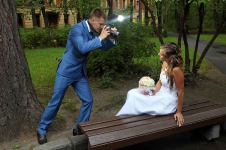 A photographer taking pictures of a bride with a bright flash.