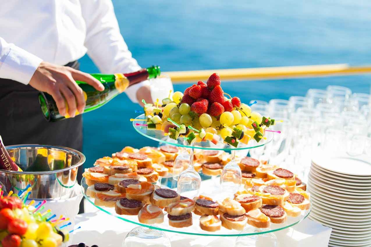 A waiter serving fruit and champagne at a wedding reception.