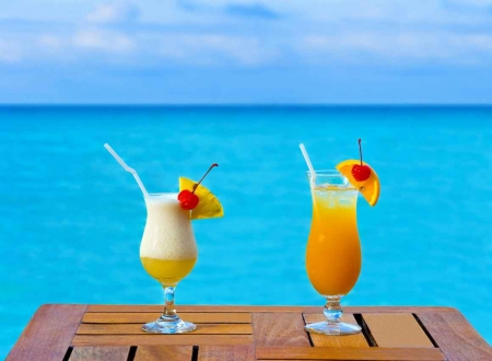 Two cocktails on a table overlooking the Caribbean Sea.