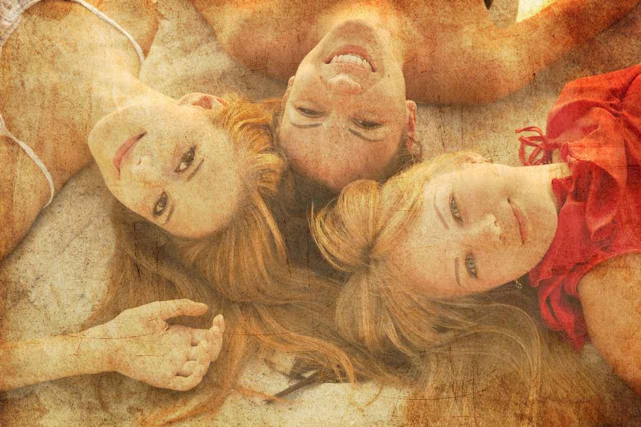 Three super hot strawberry blonde women laying on the beach.