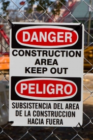 A CONSTRUCTION AREA KEEP OUT sign in both English and Spanish.