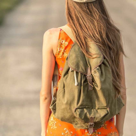 A young woman with a backpack walking down the street in Playa Del Carmen.