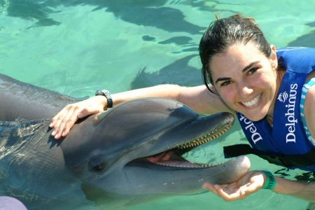 A girl swimming with a dolphin near Playa Del Carmen.