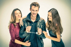 een coole man met handboeien en twee mooie vrouwen aan beide zijden van hem.