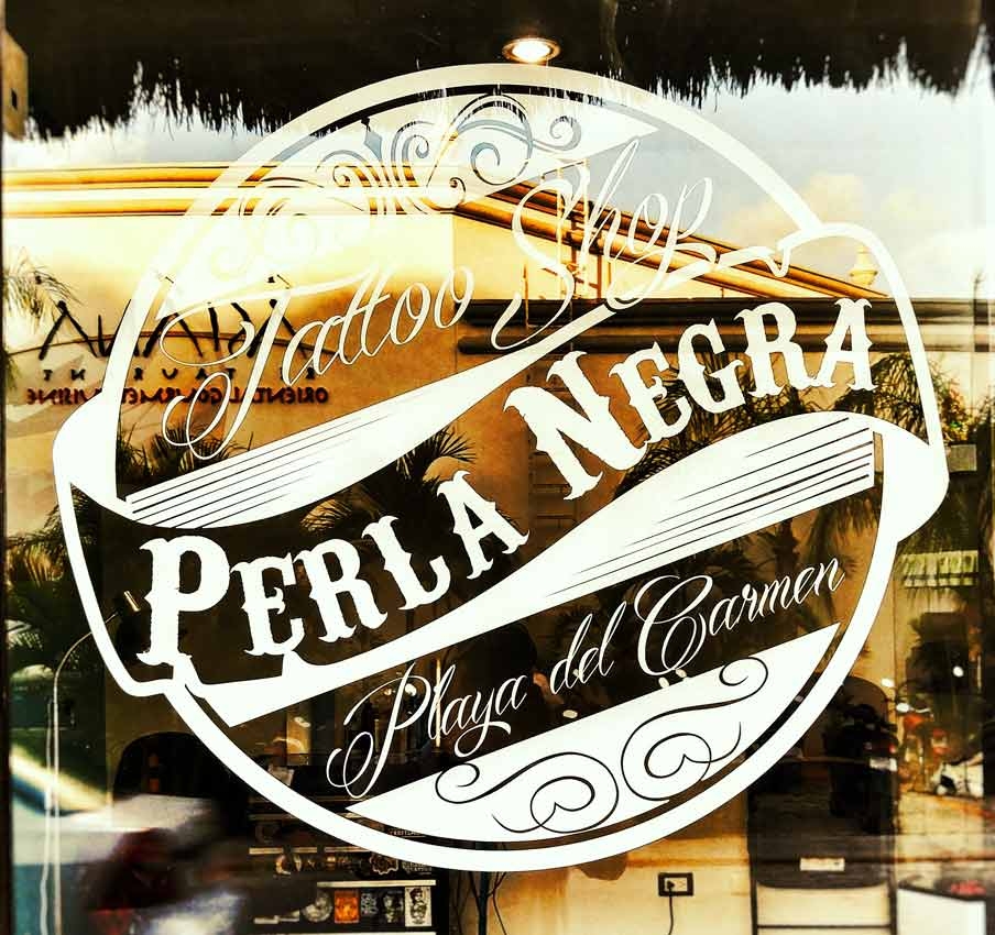 The Perla Negra sign and logo on a window in Playa Del Carmen.