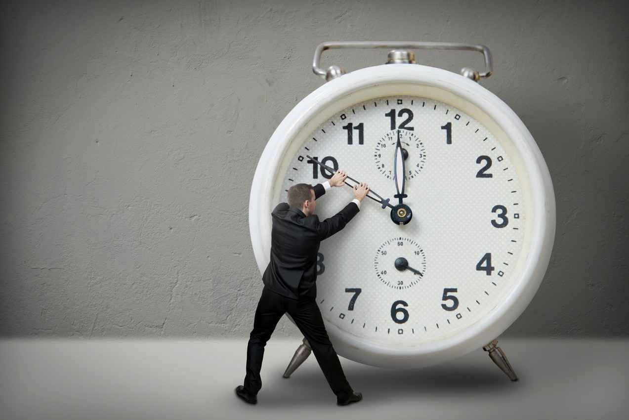 A man turning back the hands of a clock.